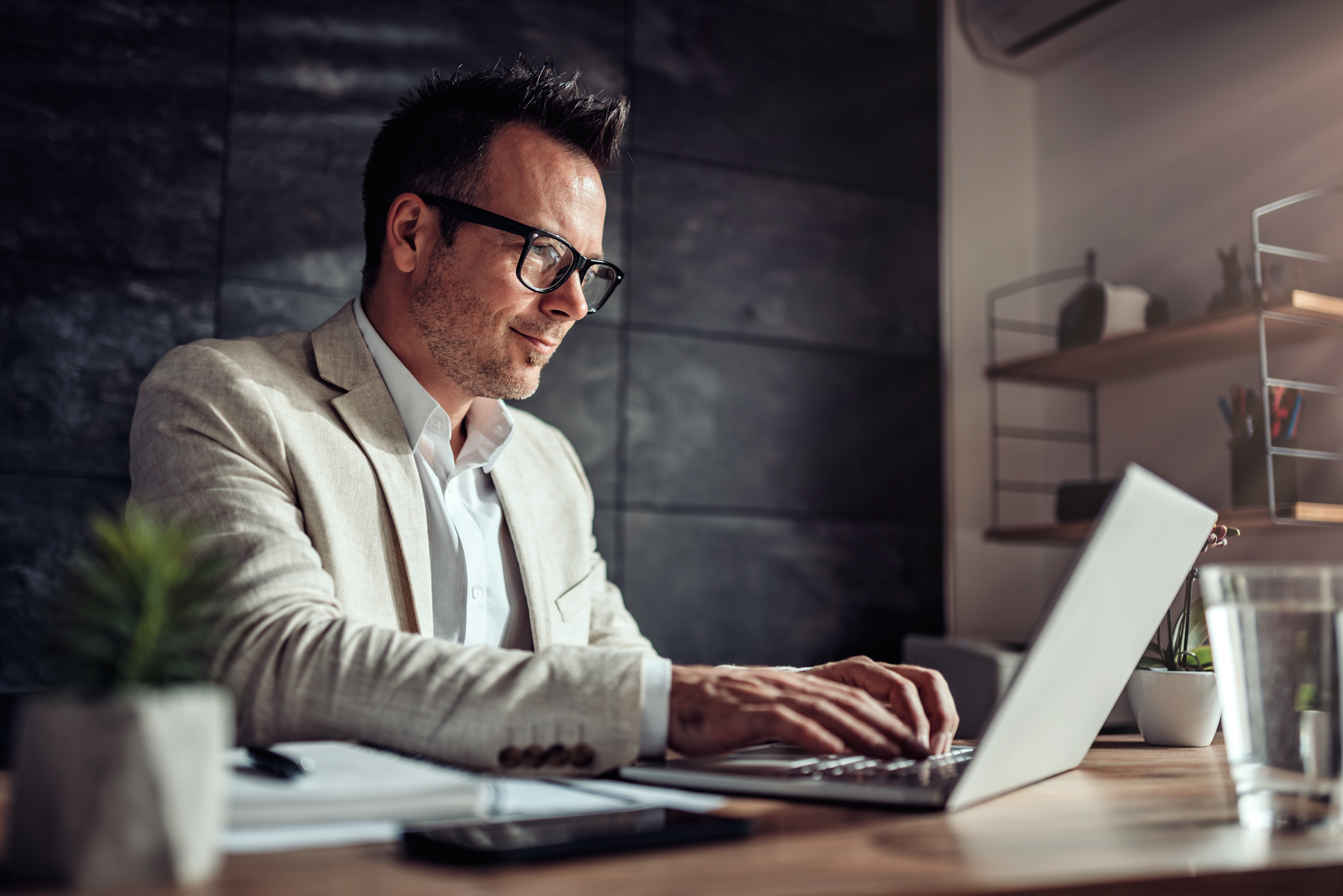 Businessman sitting at his desk and using laptop in the office