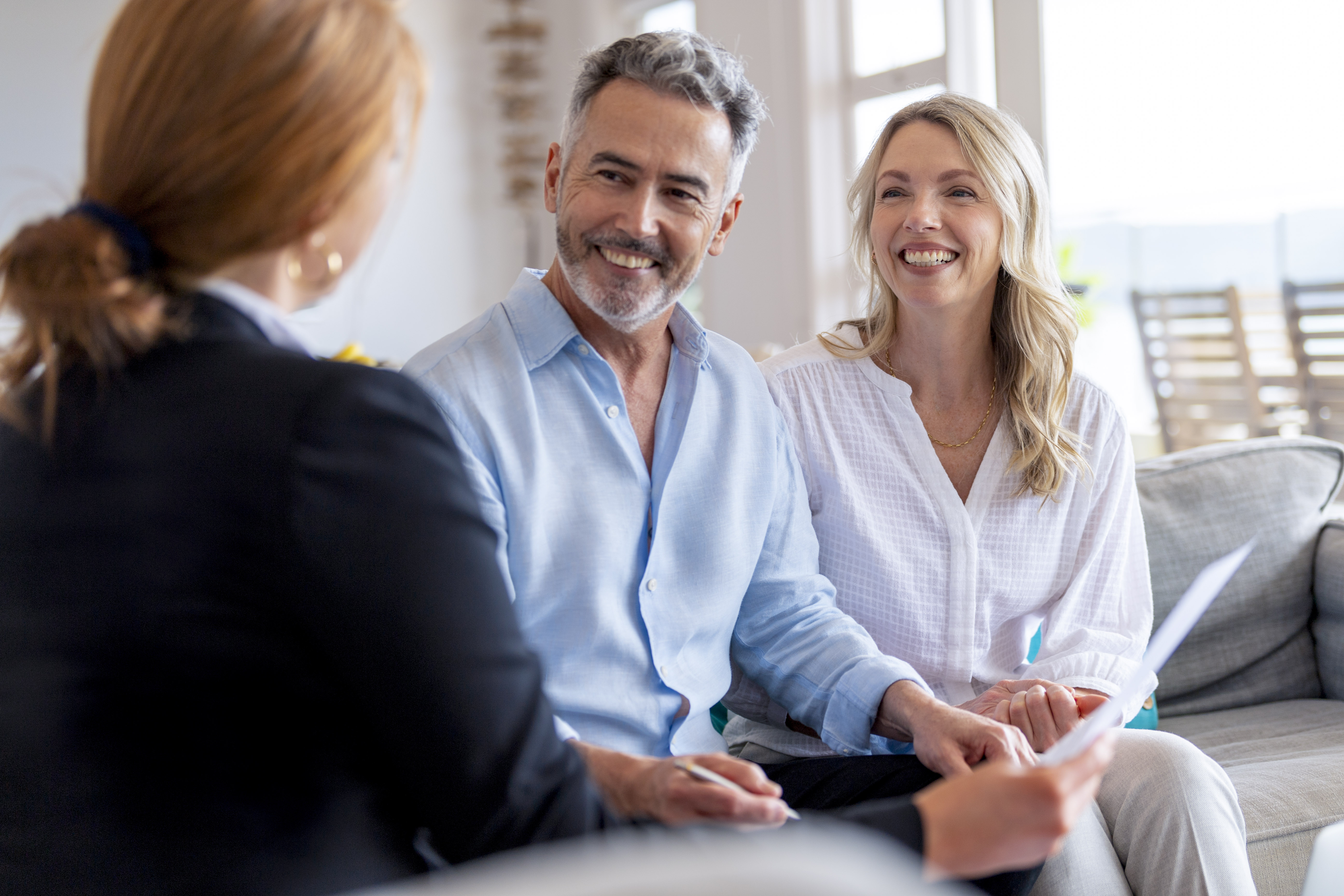 Happy mature couple meeting investments and financial advisor at home.