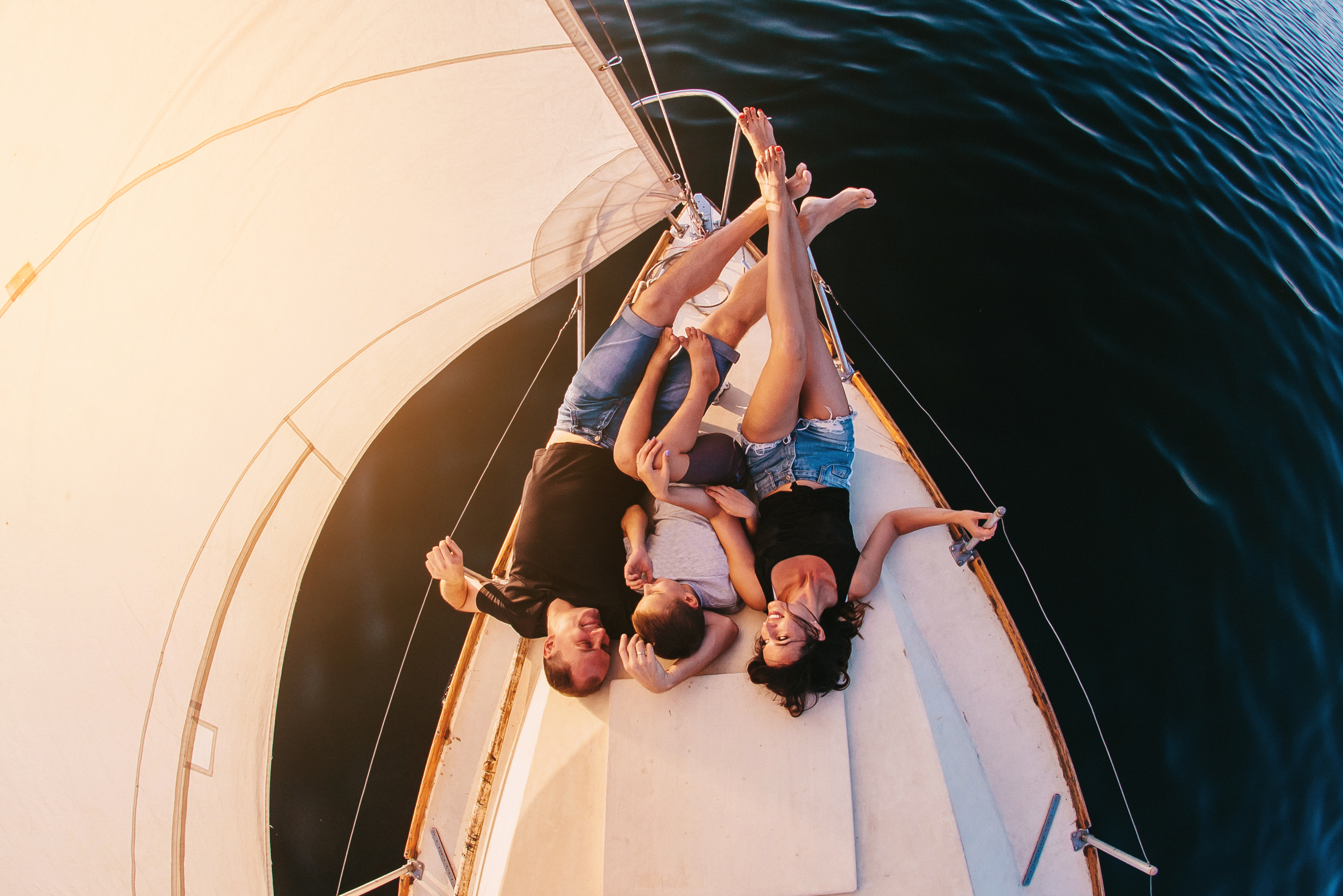 Happy family with son resting on a sailing yacht. Top view